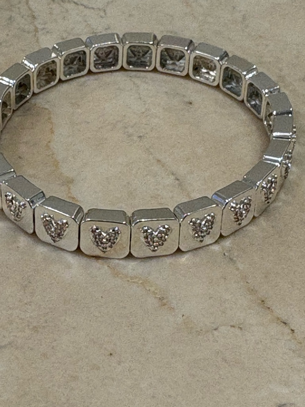 Silver puffed heart bracelet and gold smiley with green eyes